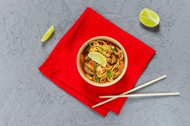 Gri bir arka plan üzerinde bir kase içinde Ramen çorbası. Asya mutfağı, yatay oryantasyon, düz yatıyordu.