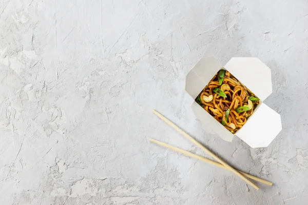 Gri bir arka plan üzerinde erişte kutusu. Asya mutfağı, yatay oryantasyon, düz yatıyordu, kopyalama alanı.