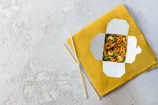 Noodles box on a gray background. Asian cuisine, horizontal orientation, flat lay, copy space.