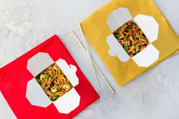 Gri bir arka plan üzerinde erişte kutusu. Asya mutfağı, yatay oryantasyon, düz yatıyordu.