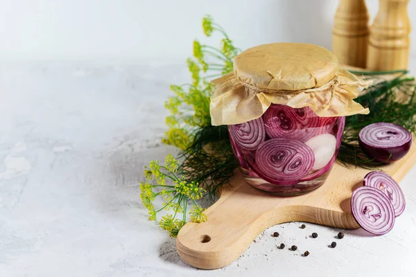 Tahta bir tahtaüzerinde bir kavanozda soğan turşusu. Mayalanmış yiyecek. Yatay yönlendirme, kopyalama alanı.