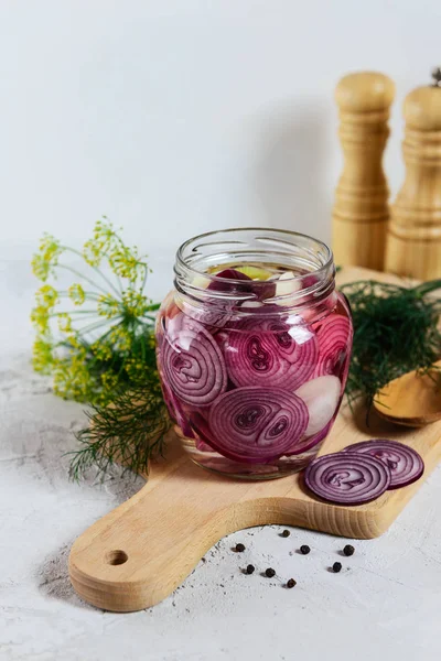 Tahta bir tahtaüzerinde bir kavanozda soğan turşusu. Fermente gıda. 
