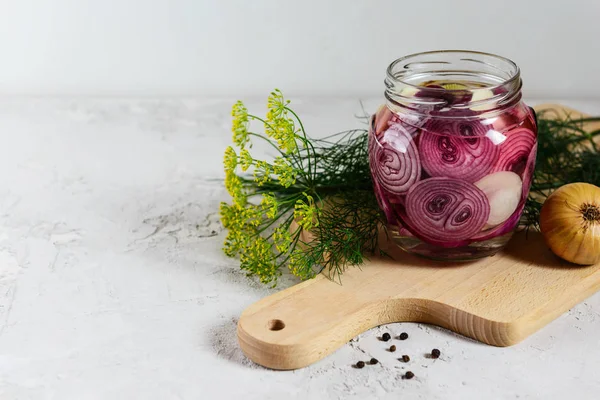 Tahta bir tahtaüzerinde bir kavanozda soğan turşusu. Mayalanmış yiyecek. Yatay yönlendirme, kopyalama alanı.