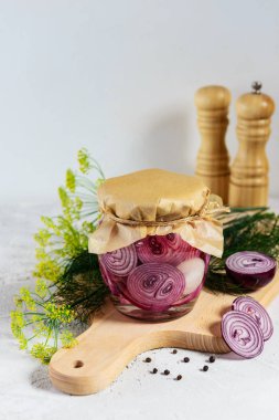 Tahta bir tahtaüzerinde bir kavanozda soğan turşusu. Fermente gıda.
