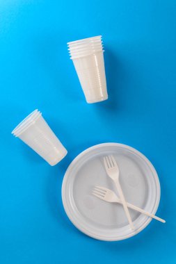 Mavi arka planda beyaz plastik tabaklar.