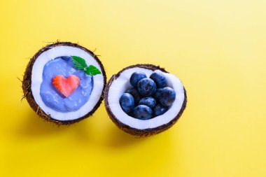 Sarı bir arka plan üzerinde bir hindistan cevizi çilek ve meyve ile Mavi matcha smoothie.