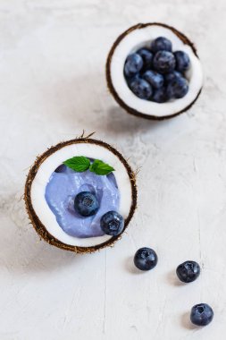 Gri bir arka plan üzerinde bir hindistan cevizi çilek ve meyve ile Mavi matcha smoothie.