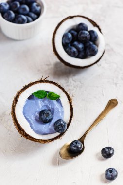 Gri bir arka plan üzerinde bir hindistan cevizi çilek ve meyve ile Mavi matcha smoothie.