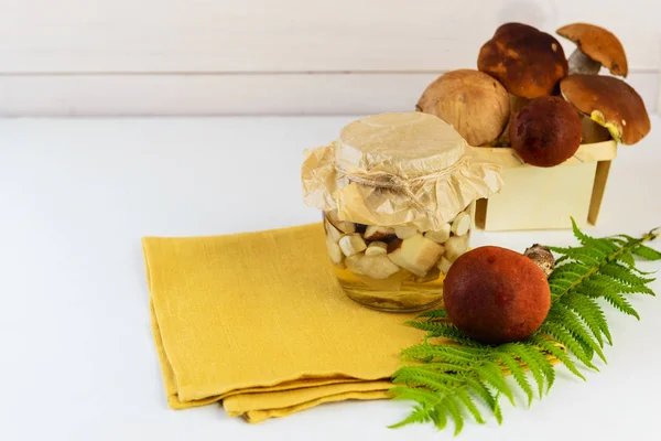 Hafif bir arka plan üzerinde bir kavanozda marine mantar. Fermente gıda, yatay oryantasyon.