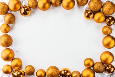 Beyaz bir arka plan üzerinde bir çerçeve şeklinde Altın Noel topları.