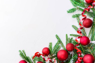 Beyaz bir arka plan üzerinde köknar dalları ile kırmızı noel topları. Kopyalama alanı, düz yatıyordu.