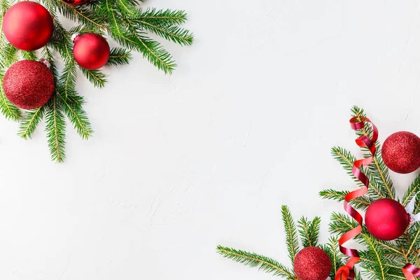 Beyaz bir arka plan üzerinde köknar dalları ile kırmızı noel topları. Kopyalama alanı, düz yatıyordu.