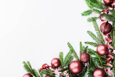 Beyaz bir arka plan üzerinde köknar dalları ile Noel topları. Kopyalama alanı, düz yatıyordu.