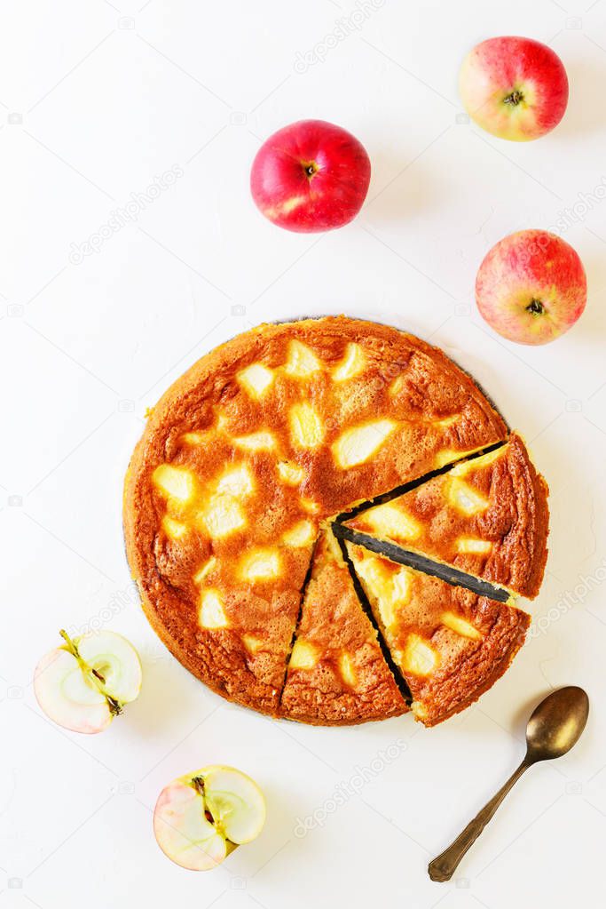 Homemade apple pie on a white table. Charlotte. Flat lay, vertical orientation, closeup.