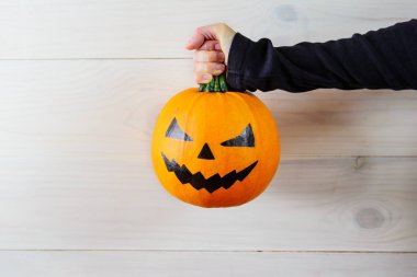Halloween. Hafif bir arka plan üzerinde ellerde Kabak.