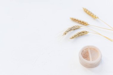 Beyaz arka planda makyaj için kullanılan mineral tozu. Uzayı kopyala, yatay yönelim.