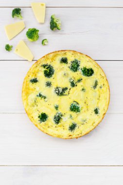 Beyaz bir masada brokoli ve peynirli ev yapımı tart. Dikey yönelim, düz yatış.