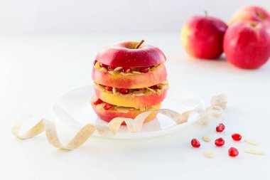 Elmalı vejetaryen burger, fındık ezmesi, nar tohumu, badem ve tahta üzerinde mezura. Uygun beslenme kavramı.