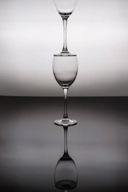 Şarap kadehleri siyah beyaz arka planda üst üste dururlar..