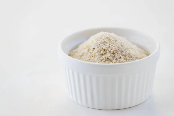 Beyaz bir kasede psilyum kabuğu. Bağırsak düzenlemeleri için doğal beslenme lifleri.