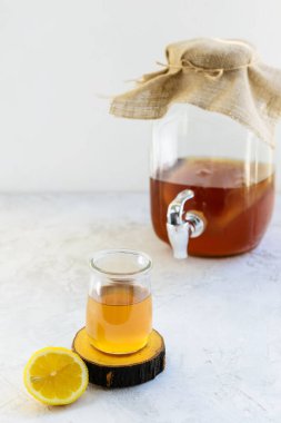 Gri bir masada limonlu ev yapımı kombu çayı. Sağlıklı içecek..