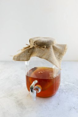 Gri bir masada, kavanozda ev yapımı kombu çayı. Sağlıklı içecek..