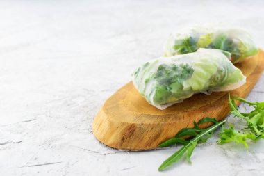 Tahta bir tahtanın üzerinde sebze rulosu pirinç kağıdı. Yatay yönelim, boşluğu kopyala.