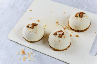 Beyaz tahtada badem ve hindistan cevizli çiğ kek. Çiğ yemek, vejetaryen, vejetaryen.