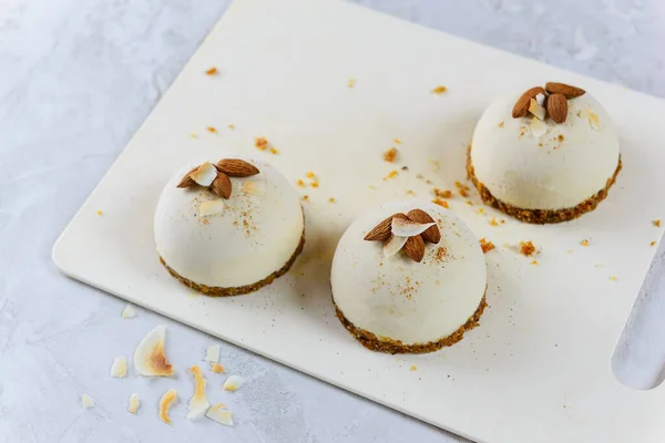 Raw cakes with almonds and coconut on a white board. Raw food dessert, vegetarian, vegan.