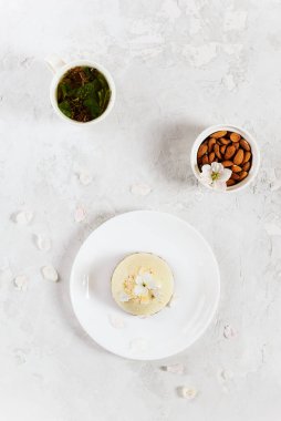 Beyaz tabakta ev yapımı çiğ bademli kek. Şeker yok, glüten yok, laktoz yok. Dikey yönelim, üst görünüm.