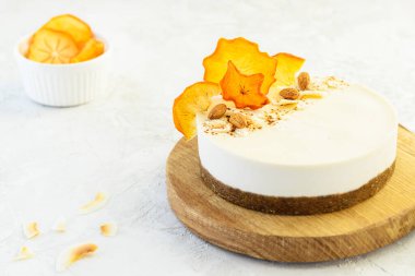 Açık arkaplanda kurutulmuş hurma olan bademli pasta. Vejetaryen tatlı, çiğ yemek diyeti. Şeker, glüten, laktoz yok..