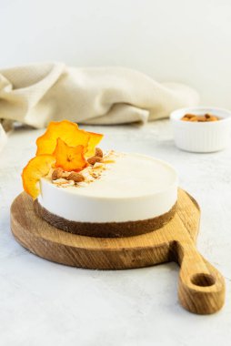 Tahta bir tahtanın üzerinde kurutulmuş hurma ile çiğ bademli kek. Vejetaryen tatlı, sağlıklı yemek. Şeker ve laktozsuz.