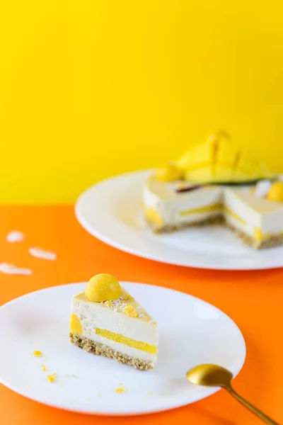 Ein Stück Roher Cashewkuchen Mit Mango Und Kokosnuss Auf Gelb — Stockfoto