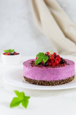 Çikolata taneli ve taze böğürtlenlerle süslenmiş ev yapımı çiğ kaju üzümlü kara frenk üzümü keki. Şeker, laktoz, glütensiz.