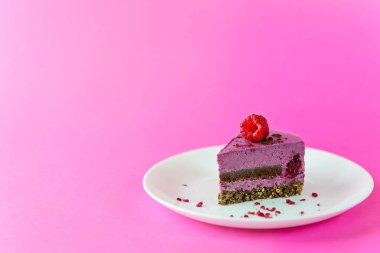 Frenk üzümlü kremalı kek ve pembe arka planda çikolatalı pralin. Şeker, laktoz, glütensiz. Yatay yönelim, boşluğu kopyala.