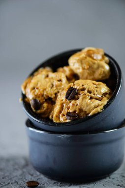 Aquafaba 'dan kahve dondurması. Gri bir masanın üzerinde topları var. Şeker, laktoz, glütensiz.