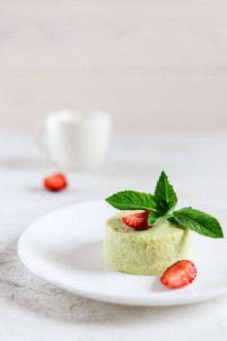 Çilekli avokado panna cotta ve beyaz tabakta nane şekeri. Şeker, laktoz, glütensiz. Sağlıklı yemek, diyet, vejetaryen.