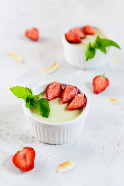 Çilekli avokado panna cotta ve beyaz kaselerde nane şekeri. Şeker, laktoz, glütensiz. Sağlıklı yemek, diyet, vejetaryen.