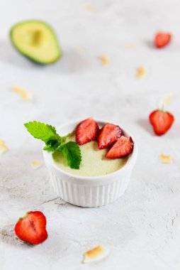 Çilekli avokado panna cotta ve beyaz bir kasede nane şekeri. Şeker, laktoz, glütensiz. Sağlıklı yemek, diyet, vejetaryen.