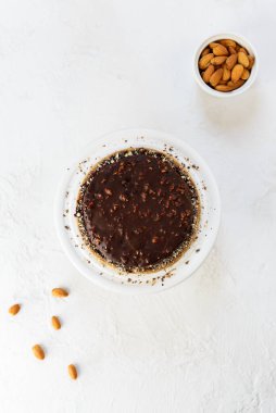 Beyaz bir masada çikolatalı bademli pasta. Şeker, laktoz, glütensiz. Dikey yönelim, üst görünüm.