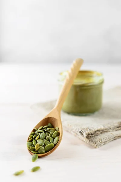 Kabak ezmesinin arka planında tahta kaşıkta kabak çekirdeği..