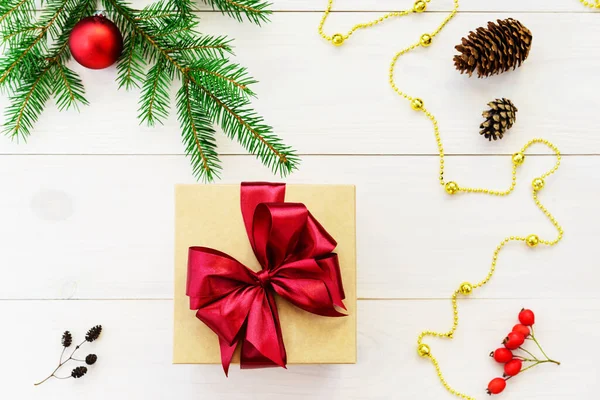 Gift box with a red bow on a light wooden background. Gift for Christmas and New Year.