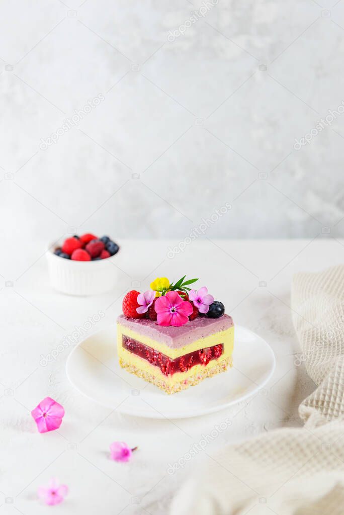 A piece of mousse raspberry lemon cake with raspberry jelly on a light background. Sugar, lactose and gluten free.