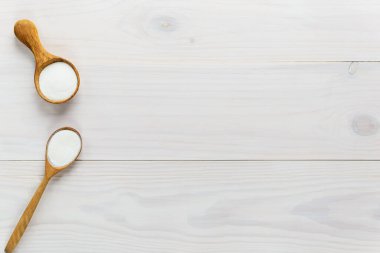 Kolajen tozu beyaz tahta bir masada kaşıklarda. Yiyeceğe besin takviyesi. Yatay yönelim, üst görünüm, kopyalama alanı.