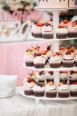 Meyve, çilek, pembe ve beyaz krema ile çikolatacupcakes çok katmanlı bir tabak bulunmaktadır. Kek üzerinde yaban mersini, ahududu, çilek, kiraz, physalis.