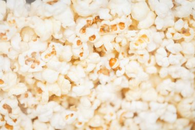 White and yellow popcorn flakes lie tightly to each other.