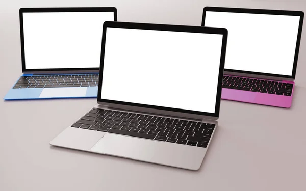 三台不同颜色的笔记本电脑和扁平的白色屏幕 图库照片