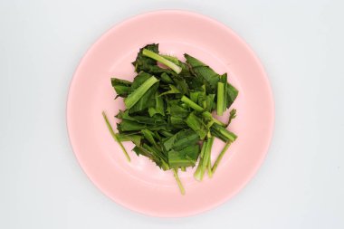 Beyaz arka plan üzerinde pembe çanak doğranmış culantro.