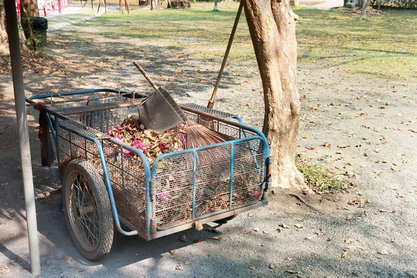 Antique steel garden trolley on ground.