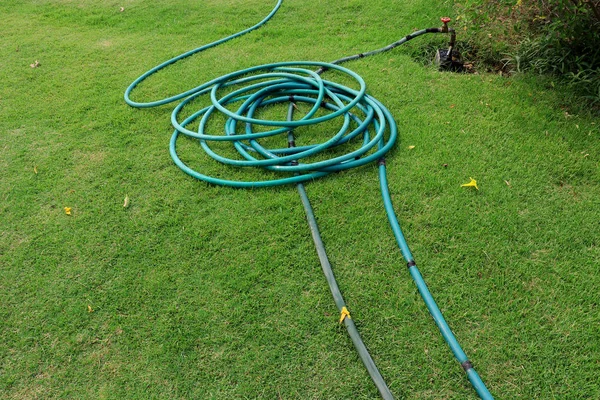 Un tubo verde sdraiato sul terreno erboso, un'immagine ravvicinata di un g — Foto Stock